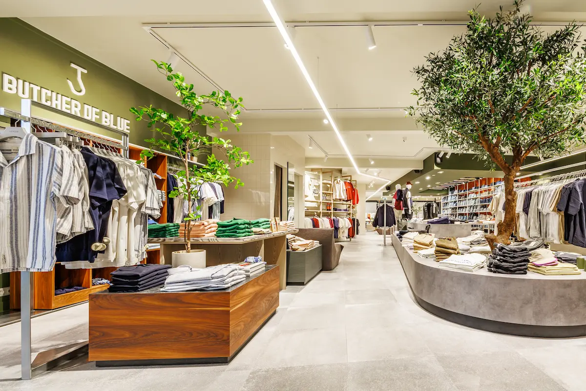Ruim overzicht van de vernieuwde herenzaak van Unique Mode met maatwerk winkelinrichting en luxe uitstraling.